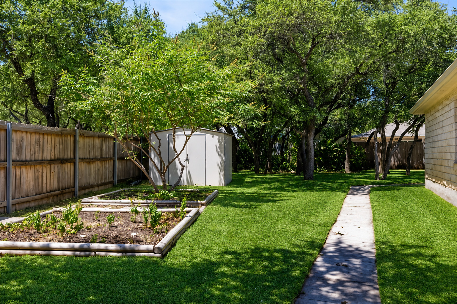 1921 Rutherford Drive Leander, TX 78641 - Photo 24 of 29 Mature trees shade a grassy lawn featuring raised garden beds and a storage shed. Virtually Enhanced.