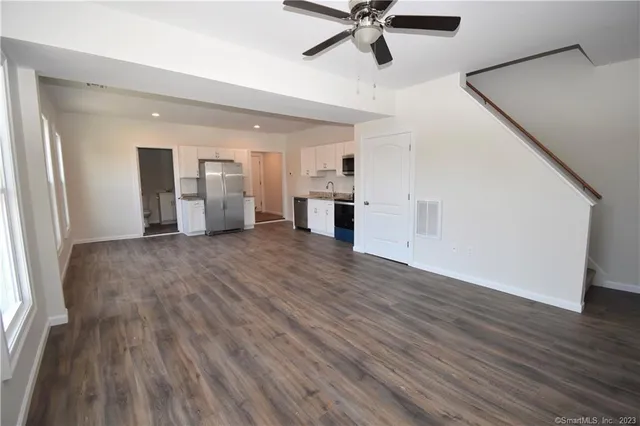 a view of a kitchen with wooden floor and a ceiling fan