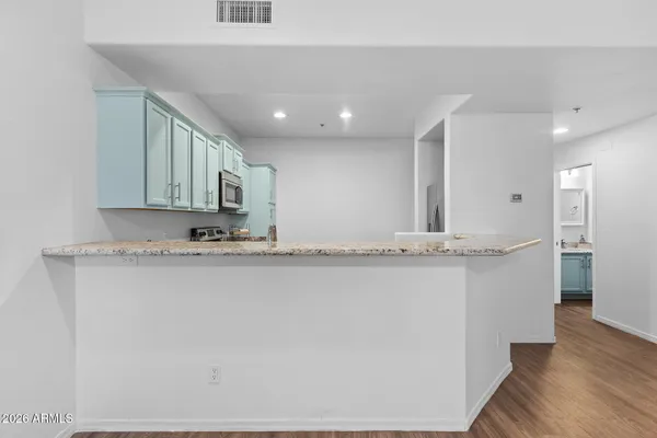 a view of a kitchen with wooden floor and a ceiling fan