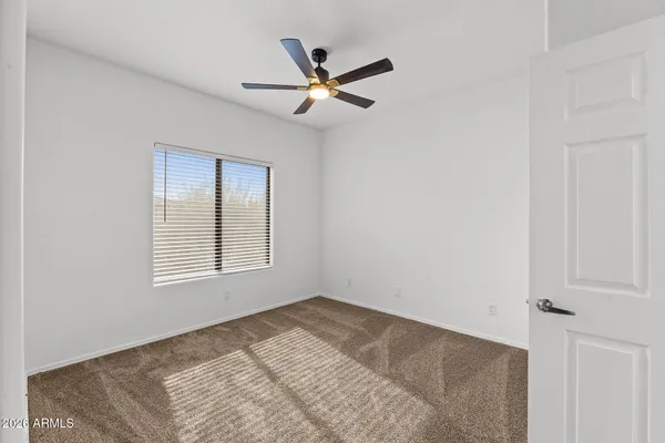 an empty room with a window and a fan