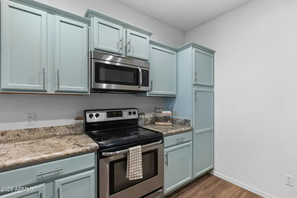 a kitchen with granite countertop white cabinets and stainless steel appliances