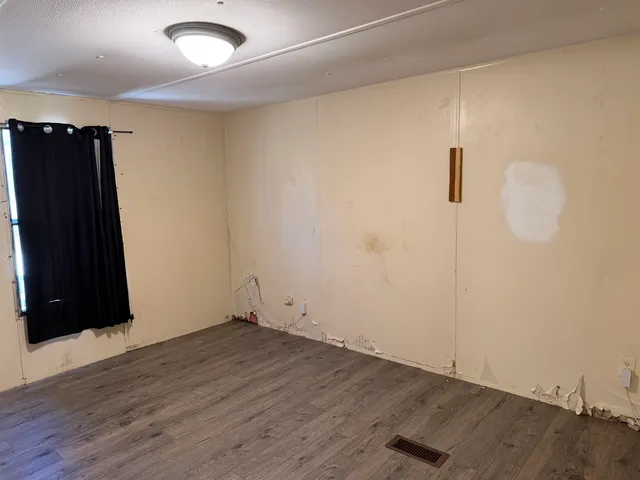 an empty room with wooden floor and closet