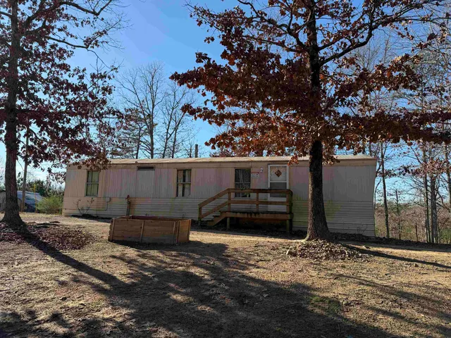 a front view of a house with a tree