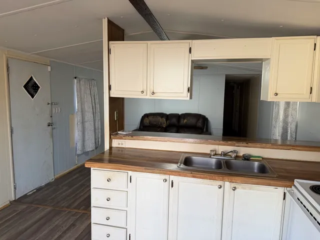 a kitchen with granite countertop white cabinets and black appliances