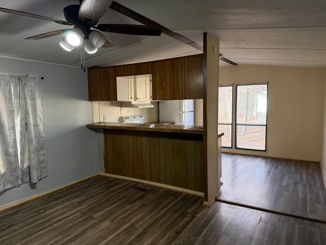 a kitchen with wooden floors and wide window