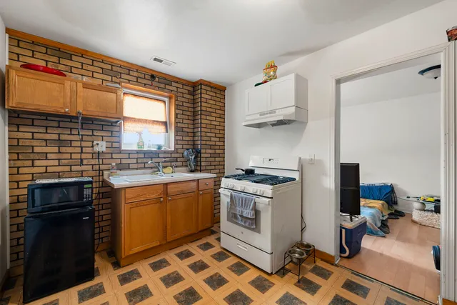 a kitchen with stainless steel appliances granite countertop a stove a sink and a refrigerator