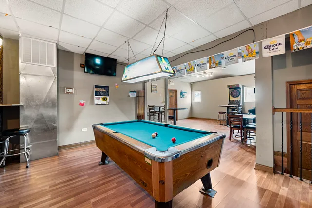 a room with wooden floor table and chairs