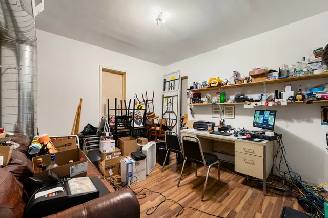 a view of a workspace with furniture and a wooden floor