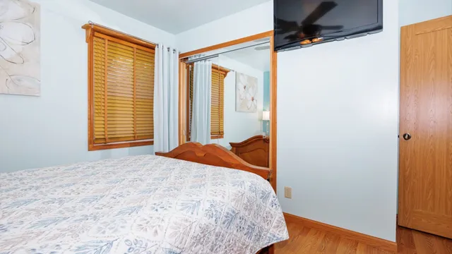 a bedroom with a bed and flat screen tv