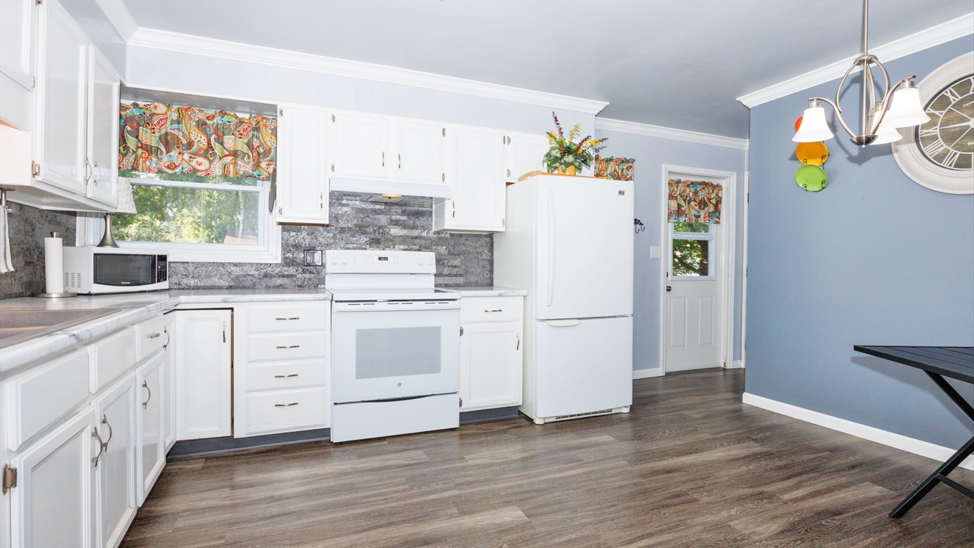210 West North Street Colfax, IL 61728 - Photo 7 of 40 a kitchen with a white refrigerator a stove and a wooden floor