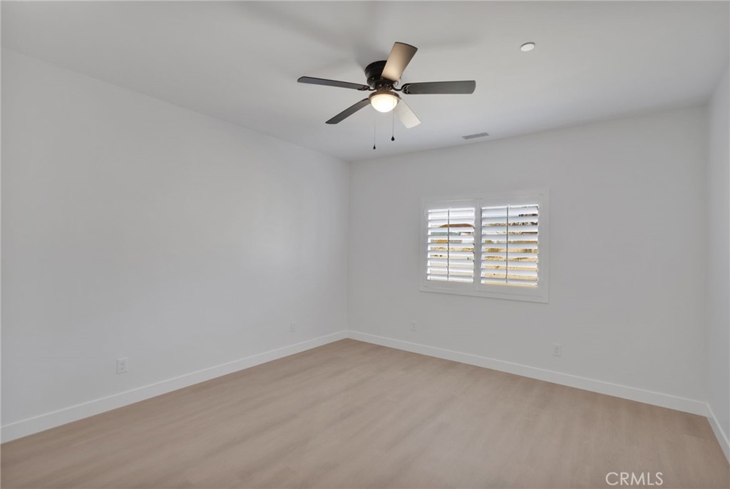 15561 Desert Star Road Apple Valley, CA 92307 - Photo 12 of 22 an empty room with a window and a fan