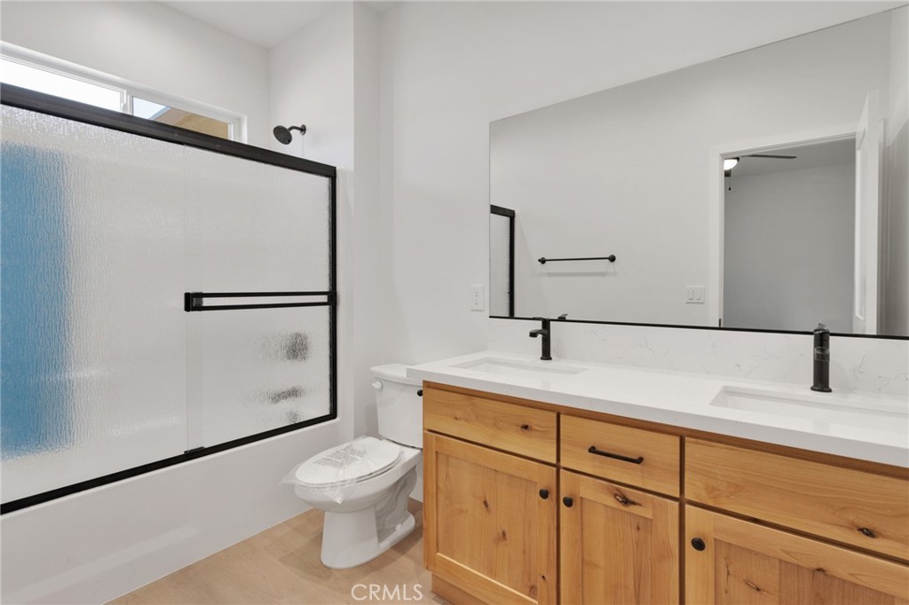 15561 Desert Star Road Apple Valley, CA 92307 - Photo 14 of 22 a bathroom with a granite countertop sink toilet a mirror and shower