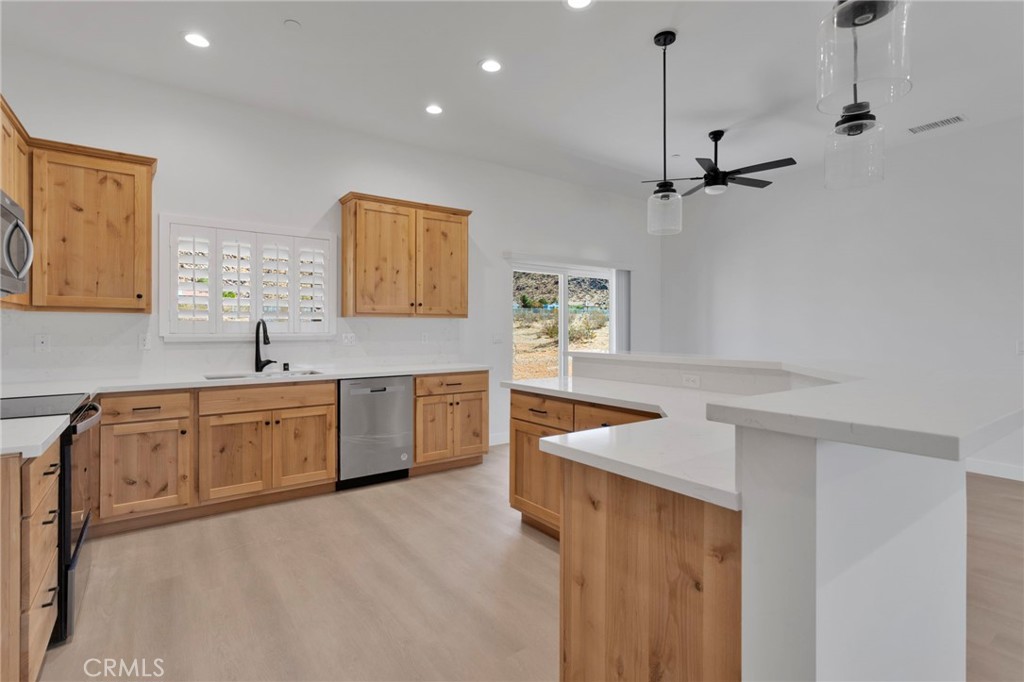 15561 Desert Star Road Apple Valley, CA 92307 - Photo 7 of 22 a kitchen with a stove a sink and a refrigerator