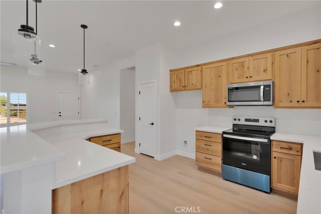 15561 Desert Star Road Apple Valley, CA 92307 - Photo 9 of 22 a kitchen with stainless steel appliances granite countertop a stove a microwave and a refrigerator