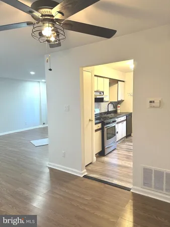 a view of a kitchen with wooden floor stainless steel appliances and a chandelier