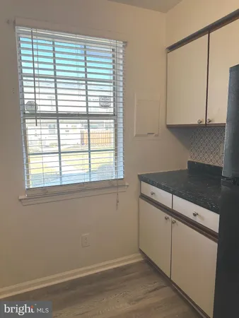 a view of a kitchen with wooden floor and a window