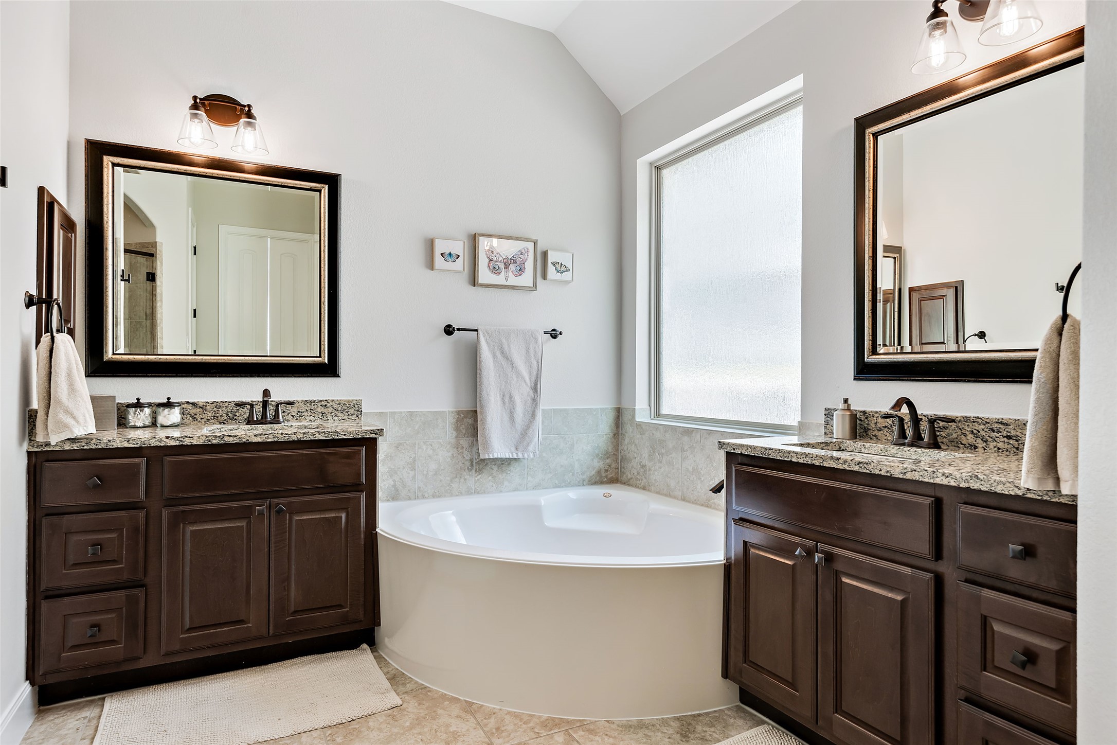 106 Maxwell Way Austin, TX 78738 - Photo 15 of 40 Full bath with a garden tub, dual vanities, light tile patterned flooring, and vaulted ceiling