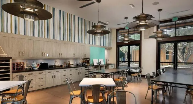 a kitchen with stainless steel appliances granite countertop a stove a sink a dining table and chairs with wooden floor