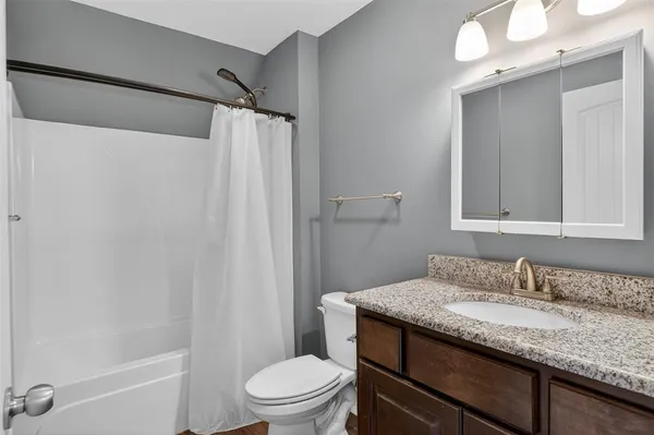 a bathroom with a granite countertop sink toilet and shower