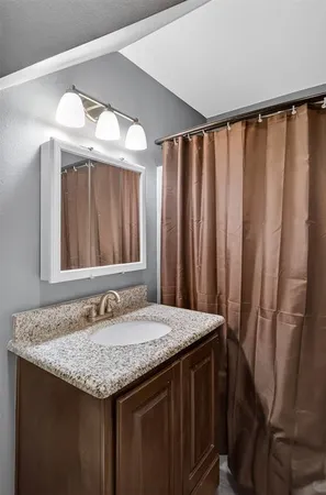 a bathroom with a granite countertop sink and a mirror