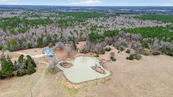 an aerial view of a house with a yard and lake view