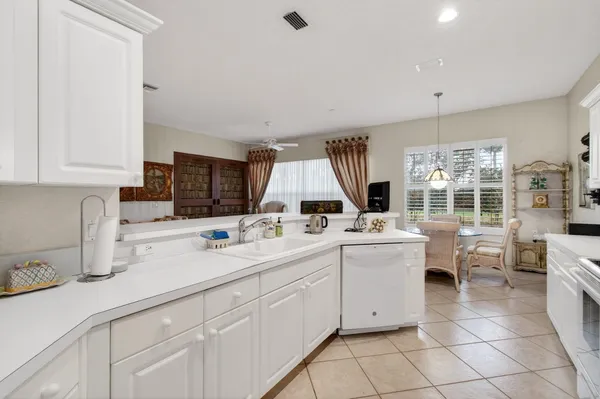 a living room with stainless steel appliances kitchen island granite countertop a sink and cabinets