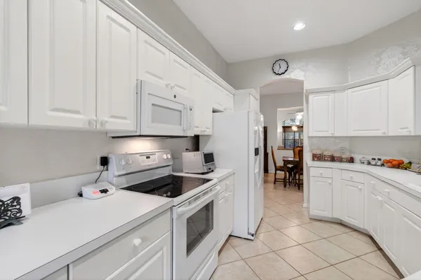 a kitchen that has a lot of cabinets in it and appliances