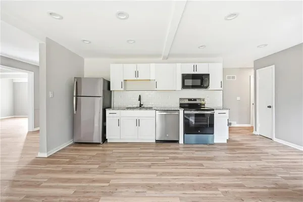 a kitchen with a refrigerator and a stove