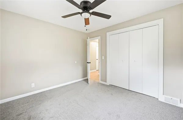 an empty room with a ceiling fan and a window