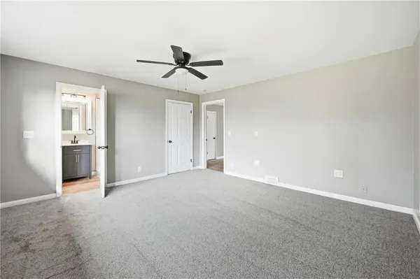 a view of empty room with wooden floor and ceiling fan