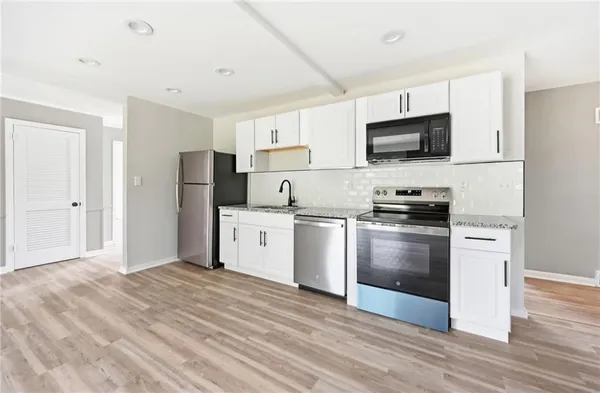 a kitchen with stainless steel appliances a refrigerator stove and microwave