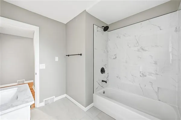 a bathroom with a shower and a bath tub