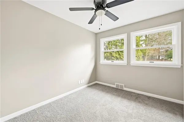 an empty room with a window and a fan