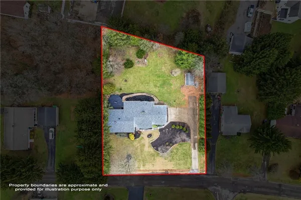 an aerial view of a residential houses with outdoor space and trees