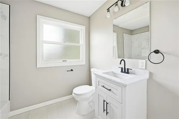 a bathroom with a toilet sink vanity and mirror
