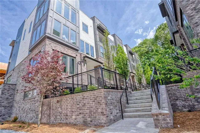 a view of a pathway that has potted plants and large tree