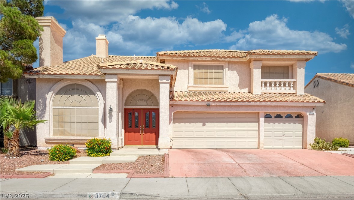 3704 North Campbell Road Las Vegas, NV 89129 - Photo 1 of 38 A terracotta-tiled roof crowns this stucco residence, featuring a welcoming double front door and three distinct garages.
