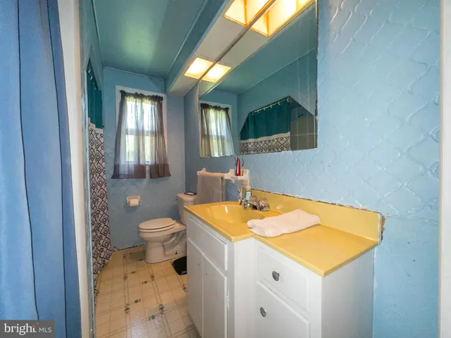 a bathroom with a sink toilet vanity and tub