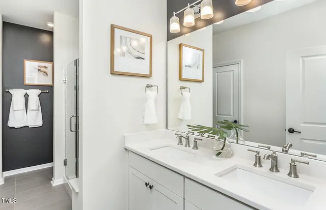 a bedroom with a bed and a lamp on dresser