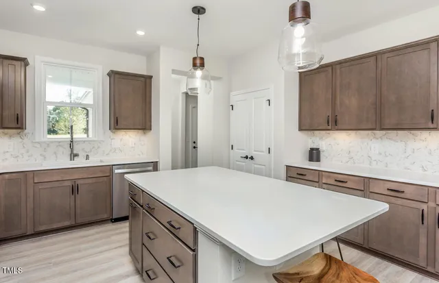 a kitchen with a table chairs refrigerator and cabinets