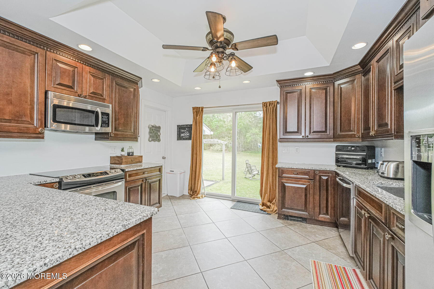 5 Riccis Drive Jackson, NJ 08527 - Photo 15 of 32 a kitchen with stainless steel appliances granite countertop a stove top oven a sink dishwasher a dining table and chairs with wooden floor