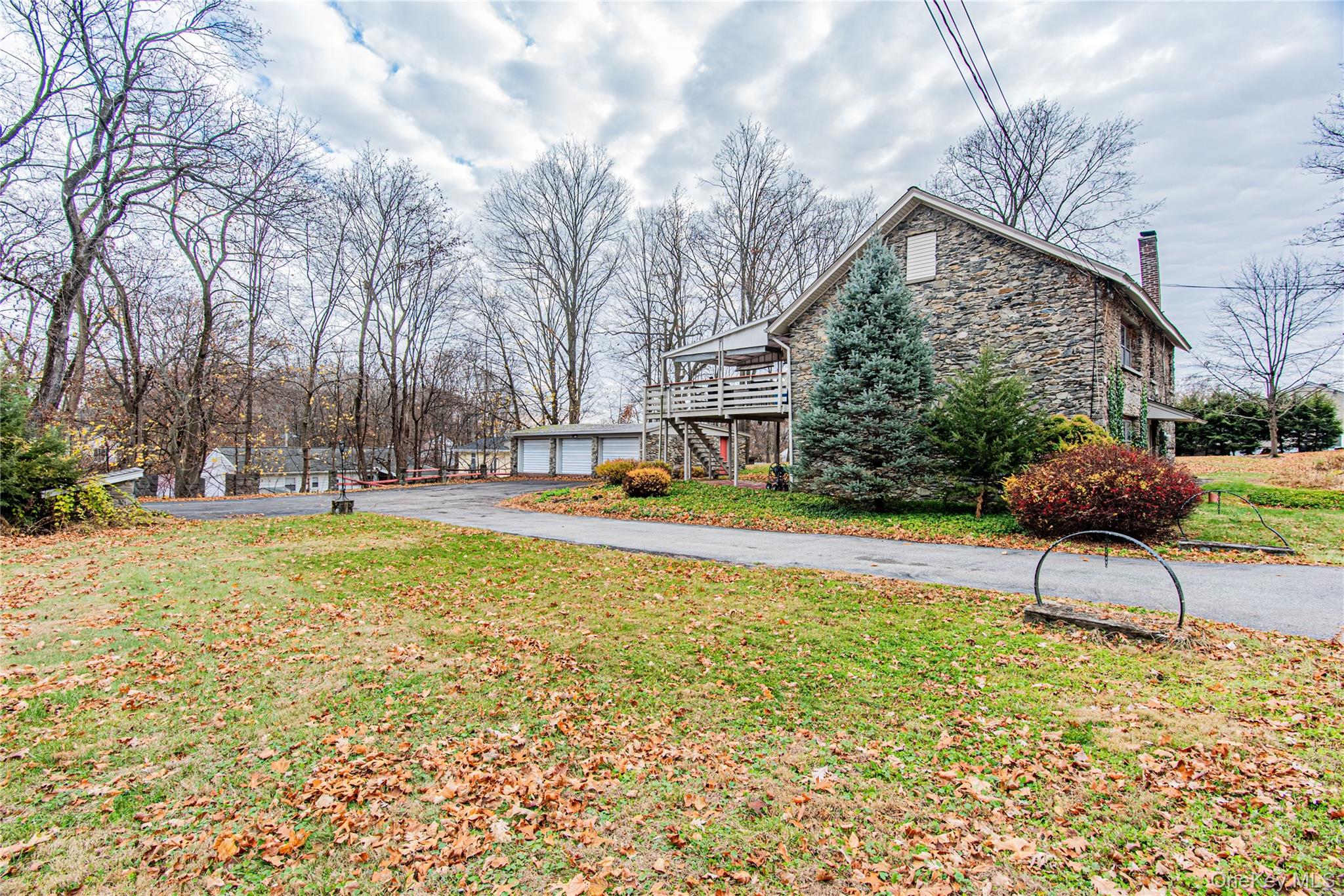 23 Musselman Drive Poughkeepsie, NY 12601 - Photo 34 of 34 View of side of property featuring stone siding, a chimney, stairway, a lawn, and a detached garage