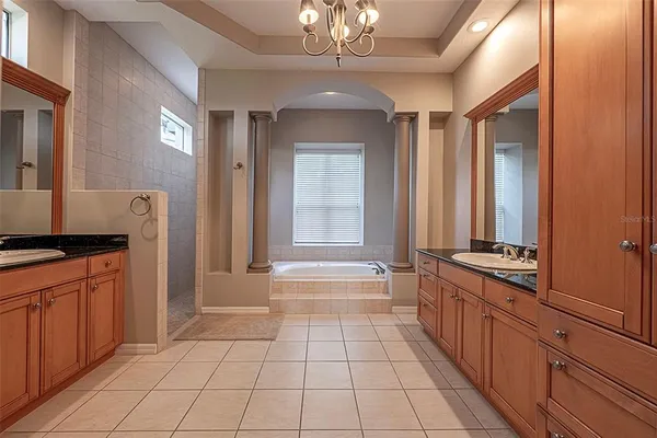 a bathroom with a granite countertop sink a toilet a mirror a bathtub and shower