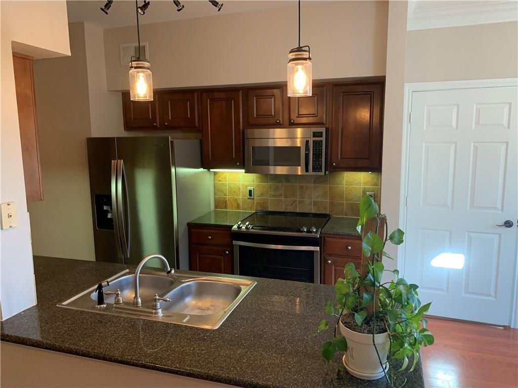 A well-appointed kitchen features rich cabinetry, sleek stainless steel appliances, and gleaming stone countertops.