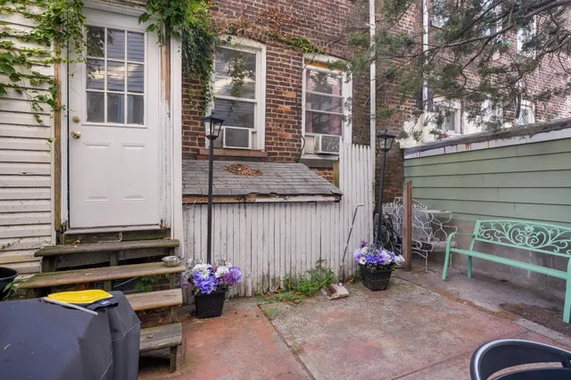 front view of a house with a chairs and potted plants