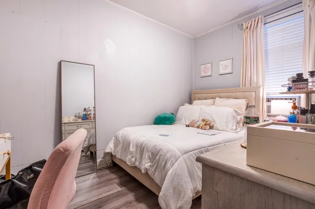 a bedroom with a bed and wooden floor