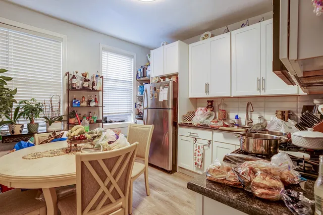 a kitchen with stainless steel appliances kitchen island granite countertop a table chairs stove and cabinets