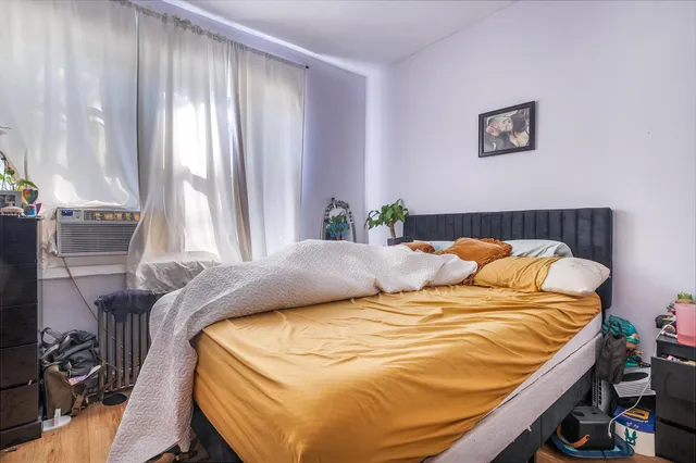 a bed sitting in a bedroom next to a window