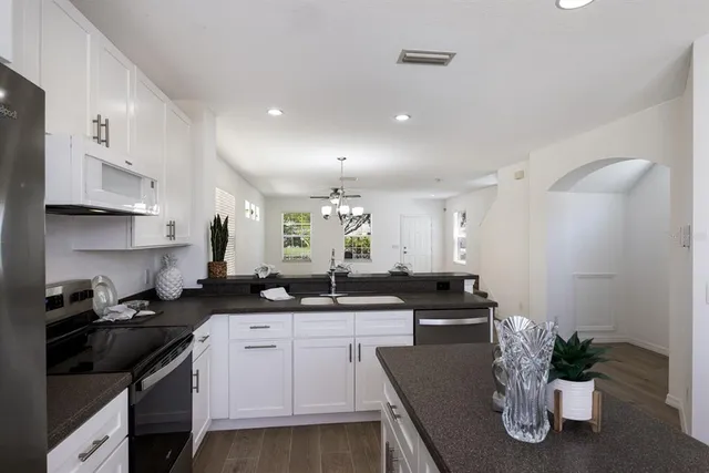 a kitchen with granite countertop a sink a stove and cabinets