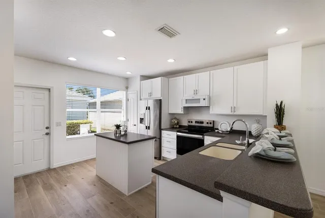 a kitchen with refrigerator and cabinets